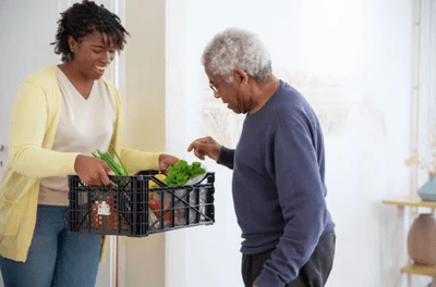 A Woman Holding a Plastic Crate with Fruits and Vegetables