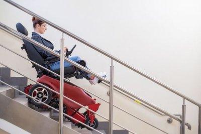 Woman in wheelchair with stair assistance technology