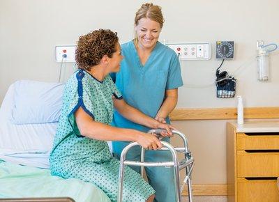 woman getting help out of a medical bed