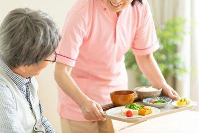 a nurese holding a tray of food to give to elderly.jpg